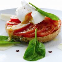 Poached egg on wholemeal bagel with tomato & spinach