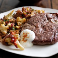 Lamb steaks with warm cauliflower, tomato & toasted pine nut salad