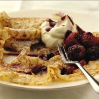 Lacy pancakes served with rosewater berries
